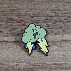 The storm cloud hard enamel pin is grey with yellow lightning bolts and blue rain drops. The pin has a drooling face!