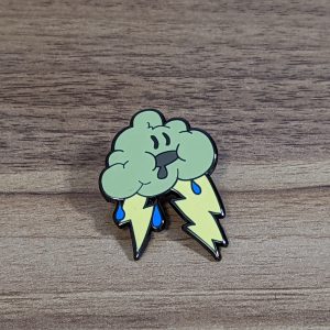 The storm cloud hard enamel pin is grey with yellow lightning bolts and blue rain drops. The pin has a drooling face!